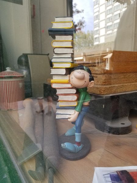 Figurine in a window carrying books